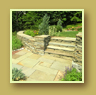 Stone stairs beside stone landing and flower plantings