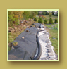 Retaining wall under construction, drainage pipe and landscape fabric
